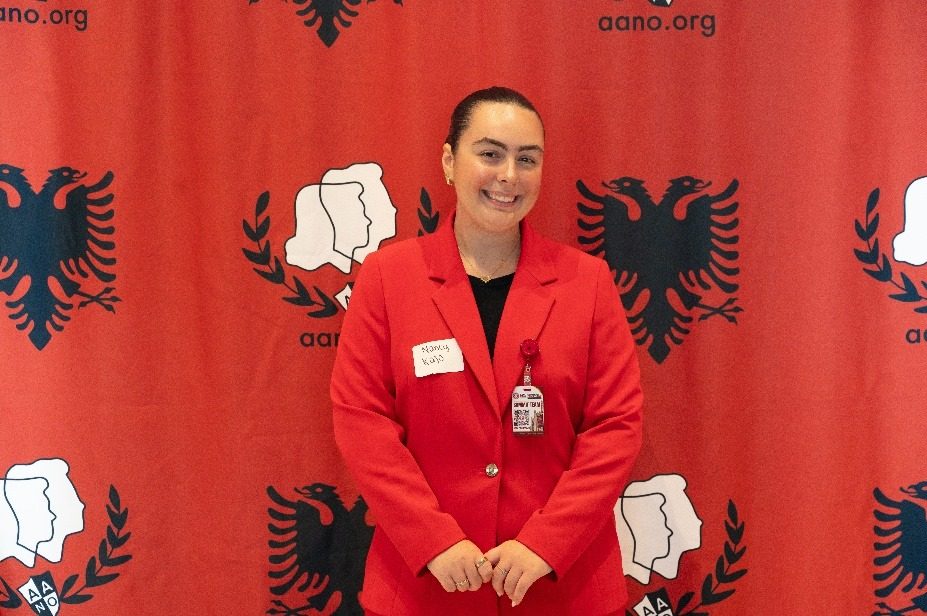 A member of the organizing committee in front of the AANO backdrop.