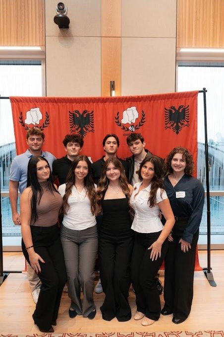Students posing together in front of the red AANO backdrop.