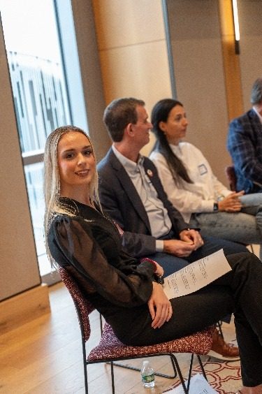 The moderator seated beside panelists during a session.