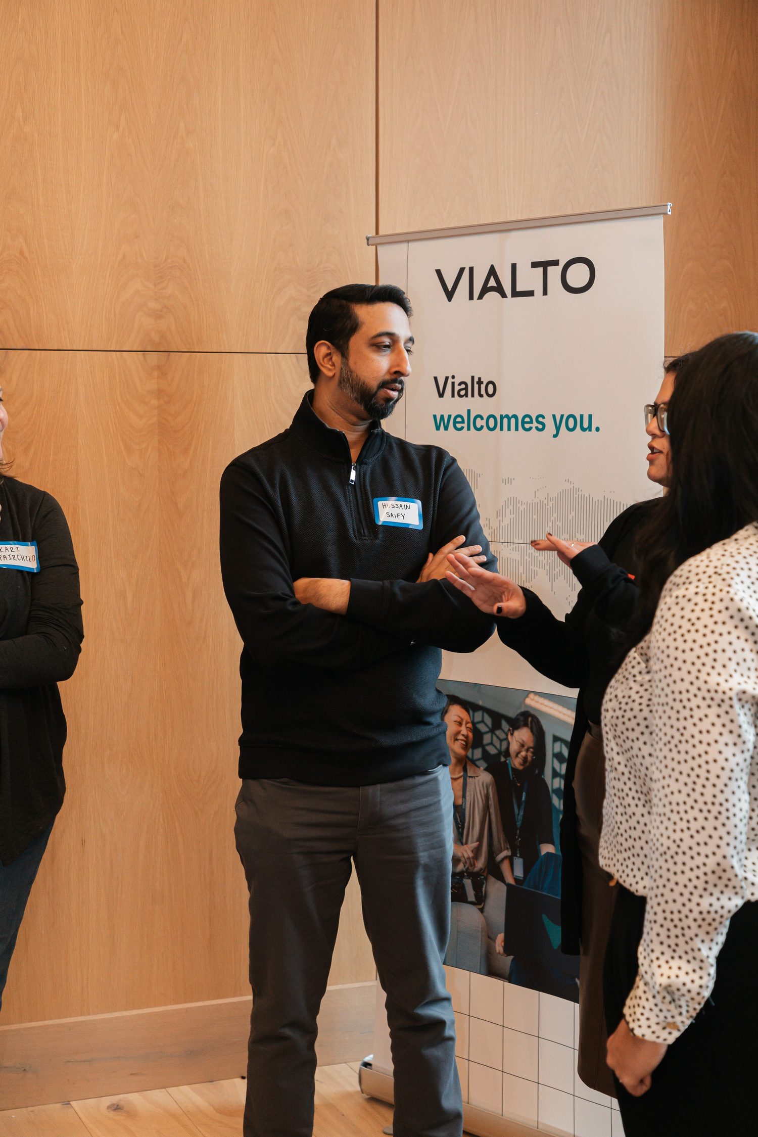 A Vialto Partners representative speaking with a student beside the company banner.