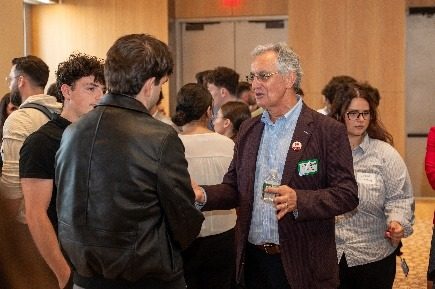 A professional in conversation with a group of students during the networking break.