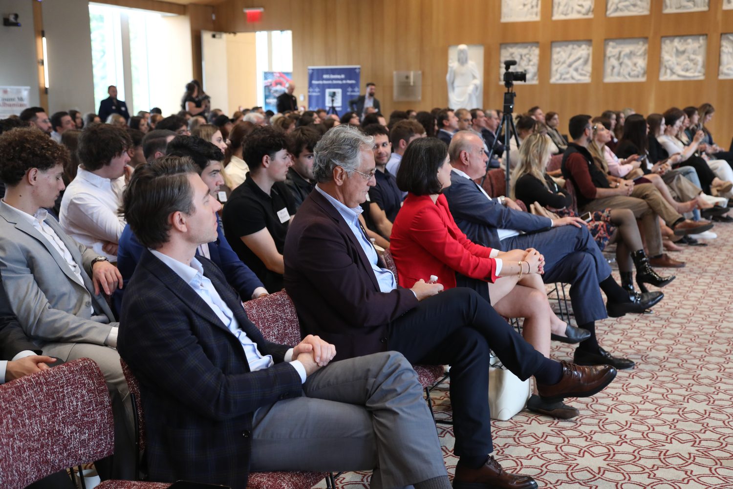Professionals and students seated together in the audience.