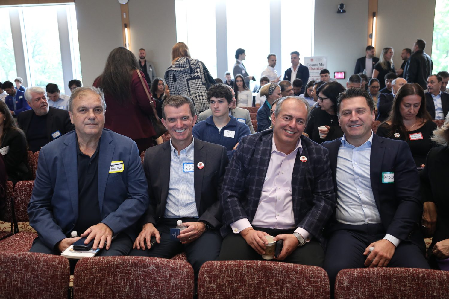 A row of professionals seated in the audience during a session.