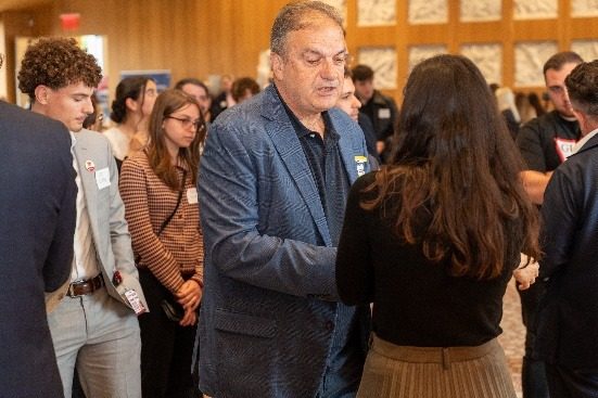 An attendee greeting students as he moves through the crowd.