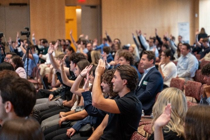 Students raising their hands during the question period.