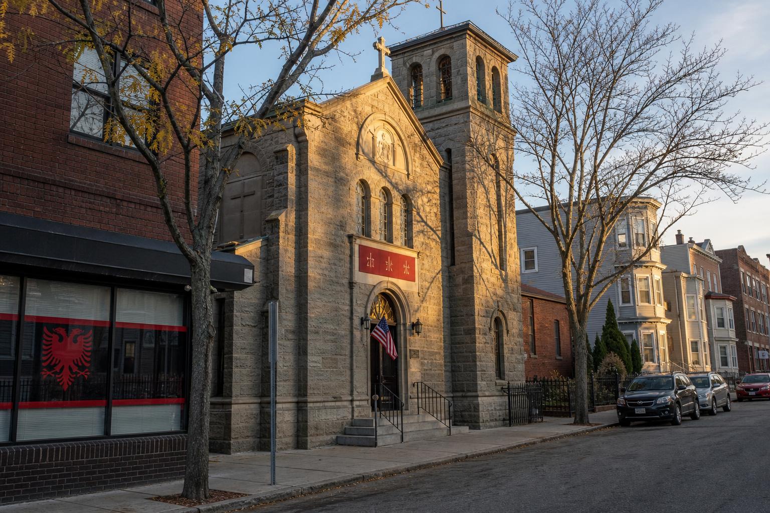 Kishë guri ortodokse shqiptare e famullisë në një bllok të qetë të South Boston-it në orën e artë, me një flamur të vogël amerikan te dera dhe një dyqan ngjitur që tregon një ngjitëse me shqiponjë dykrenore shqiptare në vitrinë.